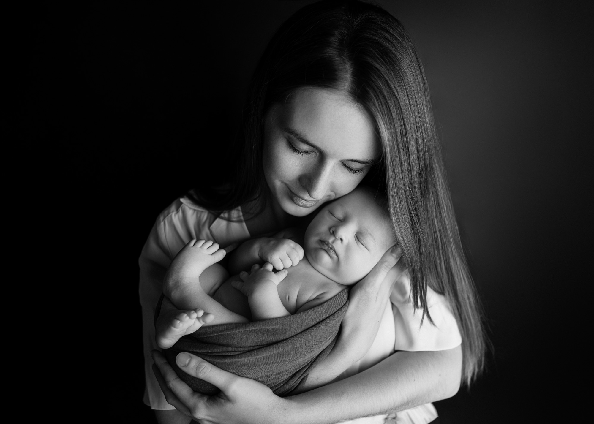 Mama tuląca noworodka, zdjęcie czarno-białe
